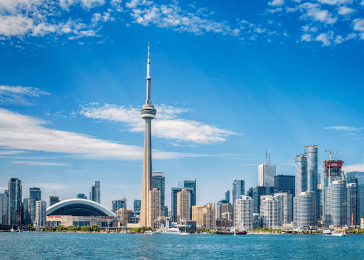 A photograph of a Canadian skyline with buildings against a blue sky with scattered clouds