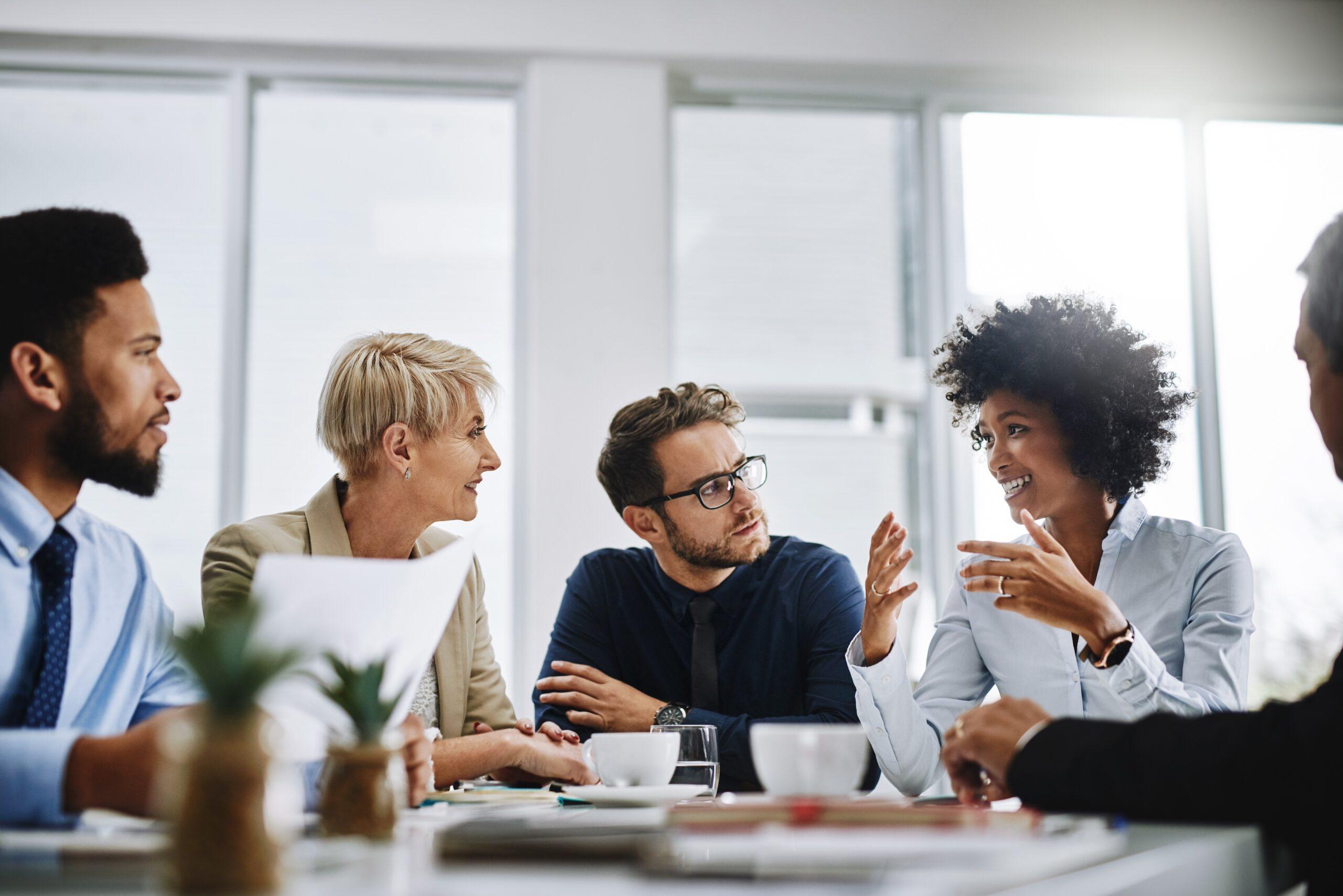 Team meeting with a woman speaking while her colleagues are actively listening