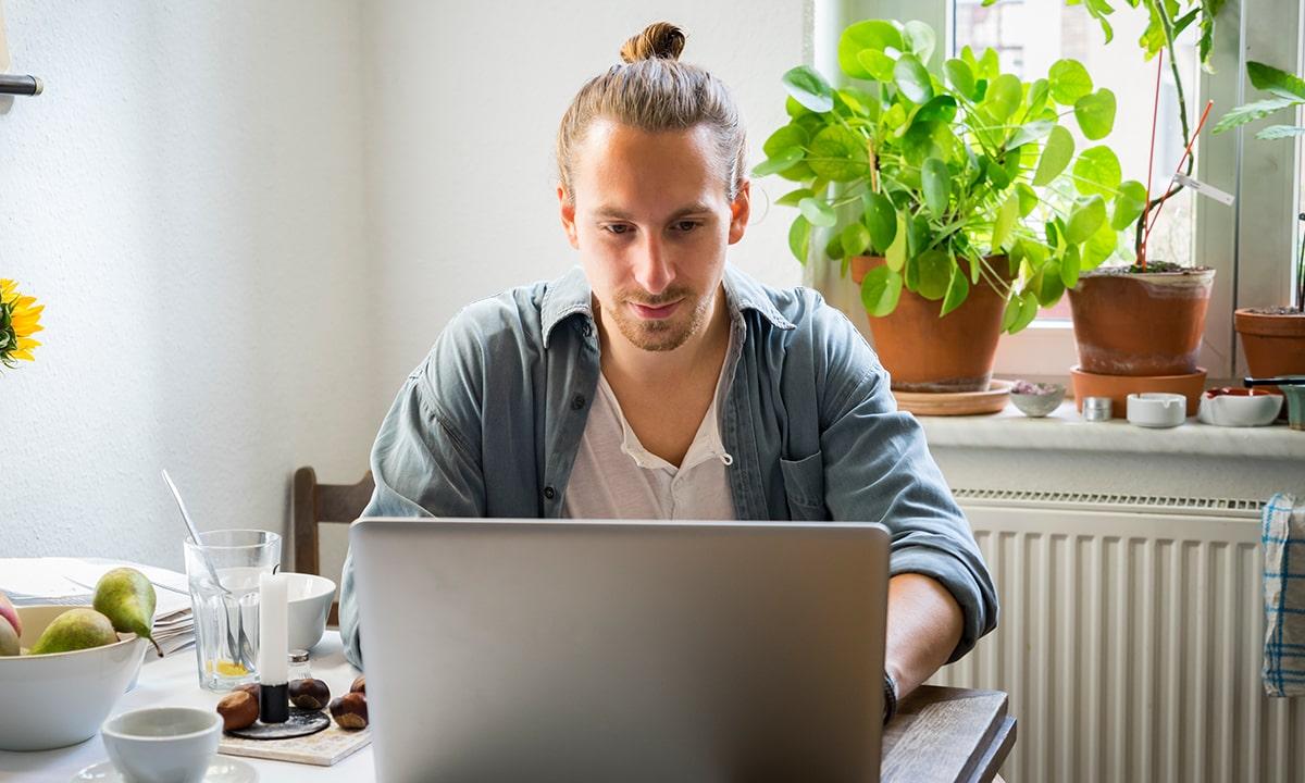 Man on computer working full-time, fully remote from home